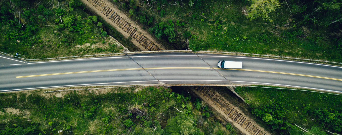 Aerial photo of a road passing over the countryside with one lone truck on it.